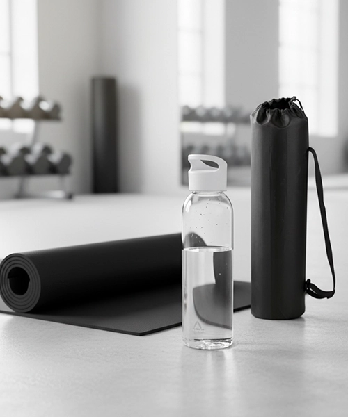 Yogamatta och vattenflaska p&aring; golvet i ett gym.