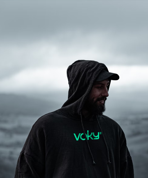 Man utomhus med svart keps och svart Voky-hoodie